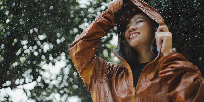 Junge frau glueclick bei regen - Regenmode