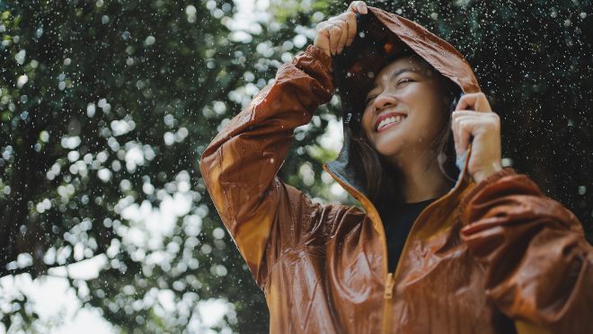 Junge frau glueclick bei regen - Regenmode