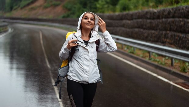 Junge Frau wandert bei Regen - Regenmode