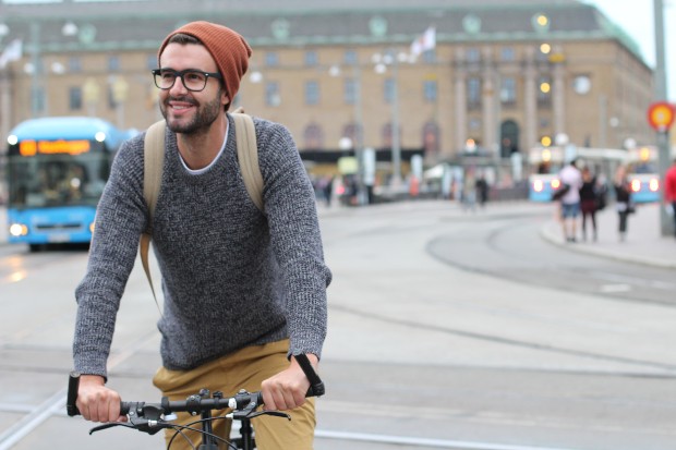 Junger Mann auf dem Fahrrad mit Beanie-Muetze