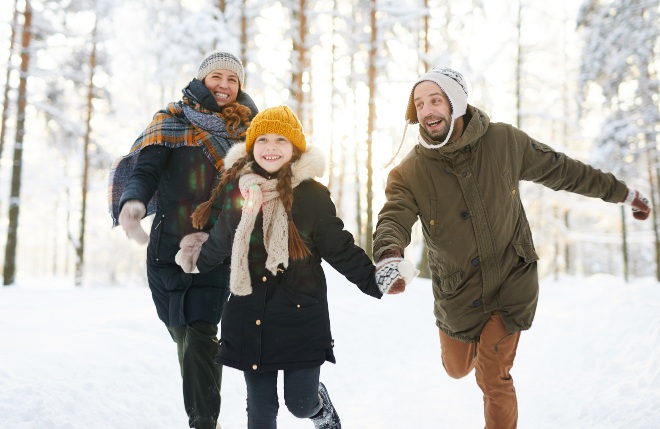 Familie im WInter, alle tragen Wintermantel