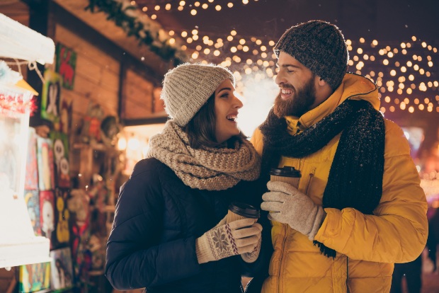 Paar auf einem Weihnachtsmarkt gekleidet in Wintermantel