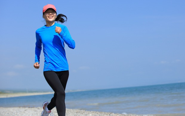Junge Frau joggt am Strand - Longsleeves kombinieren in ein sportliches Outfit
