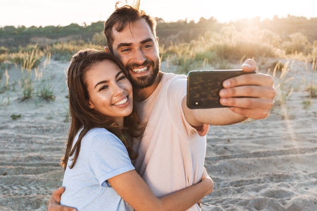 Junges Paar in T-Shirts macht Selfie