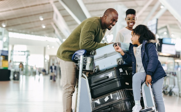 Familie-mit-Koffern-am-Flughafen - Wie viel Kleidung für 14 Tage Urlaub