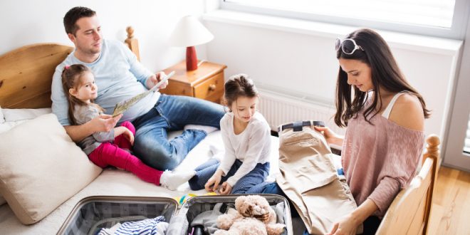 Junge Familie packt Kocffer - Wie viel Kleidung für 14 Tage Urlaub