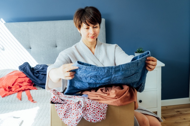 Eine Frau betrachtet eine Hose, die sie vielleicht nicht mehr tragen will