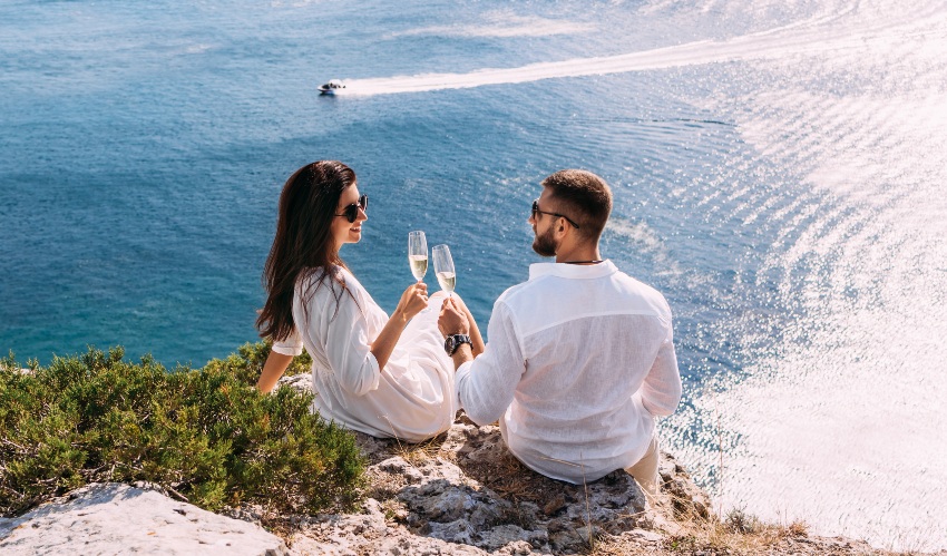 Junges-Paar-im-Urlaub-mit-Sekt - Weißes Outfit zusammenstellen