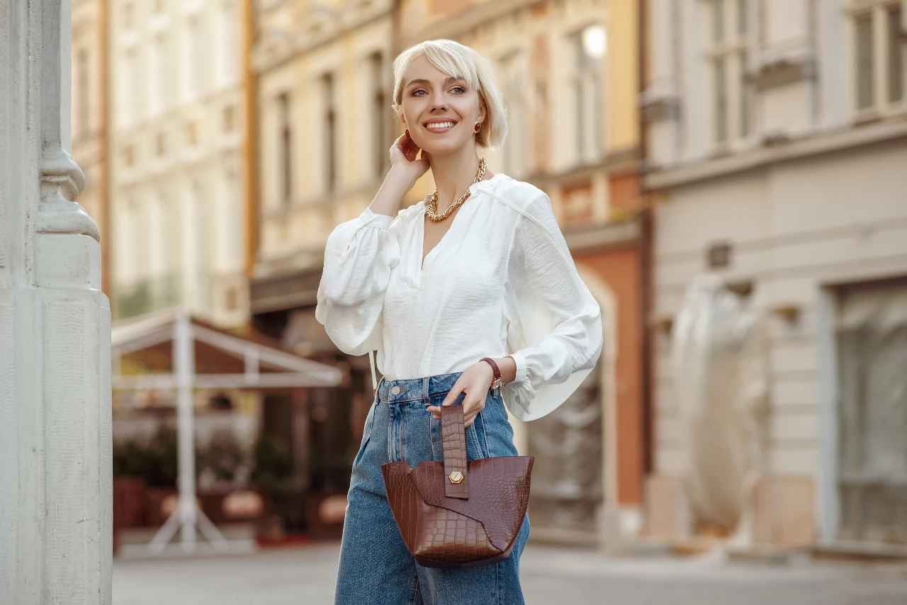 Frau trägt zum Stadtbummel weiße Bluse mit Jeans 