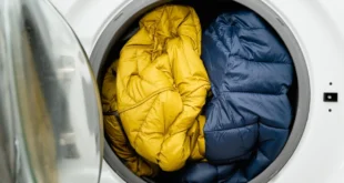Daunenjacken liegen in der Trommel einer Waschmaschine
