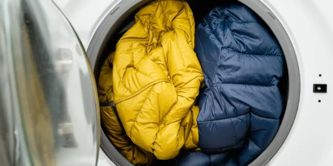 Daunenjacken liegen in der Trommel einer Waschmaschine