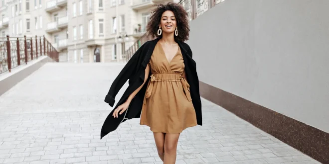 Kleidung für Figurtyp-X – Frau trägt in Kleid in Cognax und einen scharzen Trenchcoat