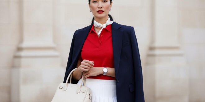 Tenniscore Modetrend Stylingideen, Frau trägt weißen Tennisrock mit roten Poloshirt und dunkelblauem Blazer