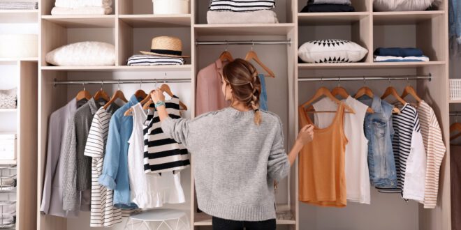 Junge-Frau-sucht-Kleidung-aus-Kleiderschrank