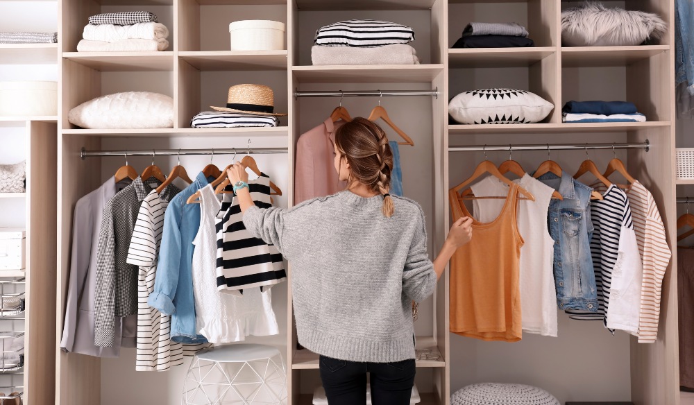 Junge-Frau-sucht-Kleidung-aus-Kleiderschrank