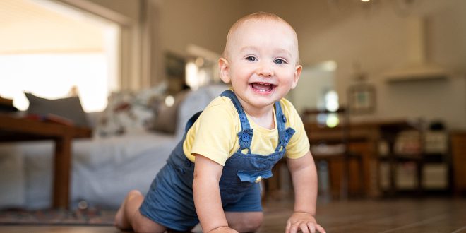 Fröhliches-Baby-in-Latzhose